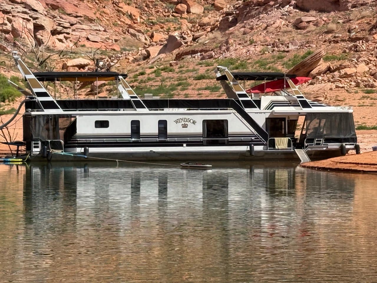 The Windsor — a 1998 JamesTowner 70' houseboat moored at the red rock shore of Lake Powell
